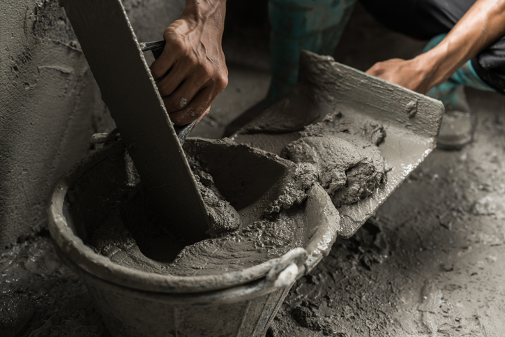 Hand plaster worker cement mix background construction house site, Mortar concrete wet bucket trowel tool plastering well free space for text